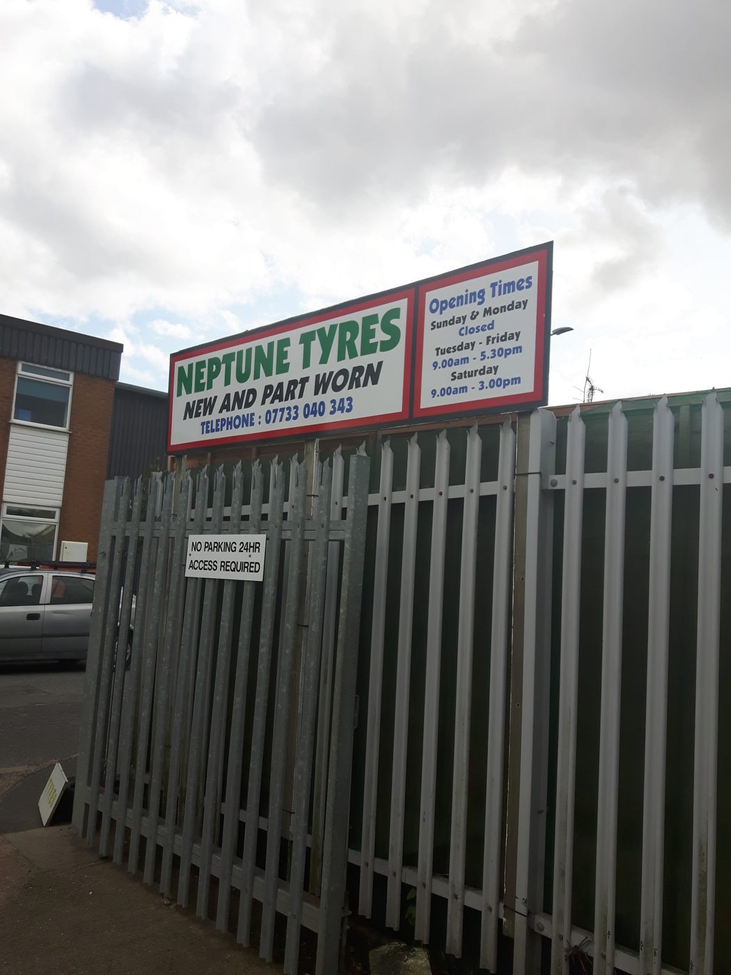The Neptune Tyres roadside sign: New and part worn, with the phone number and opening times