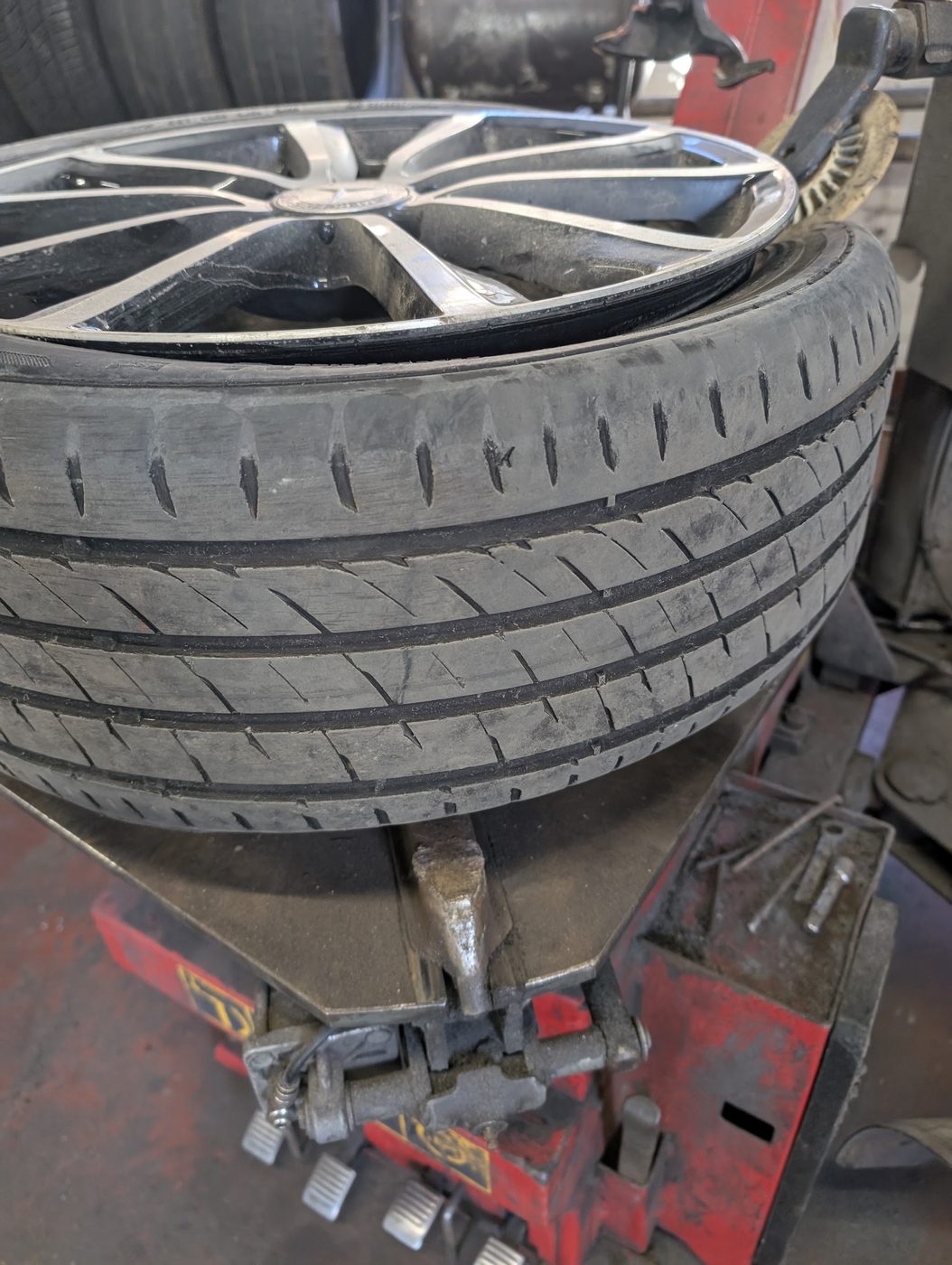A low profile tyre going onto an alloy wheel on the tyre changing machine